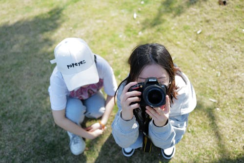 Foto profissional grátis de boné branco, câmera nikon, crianças