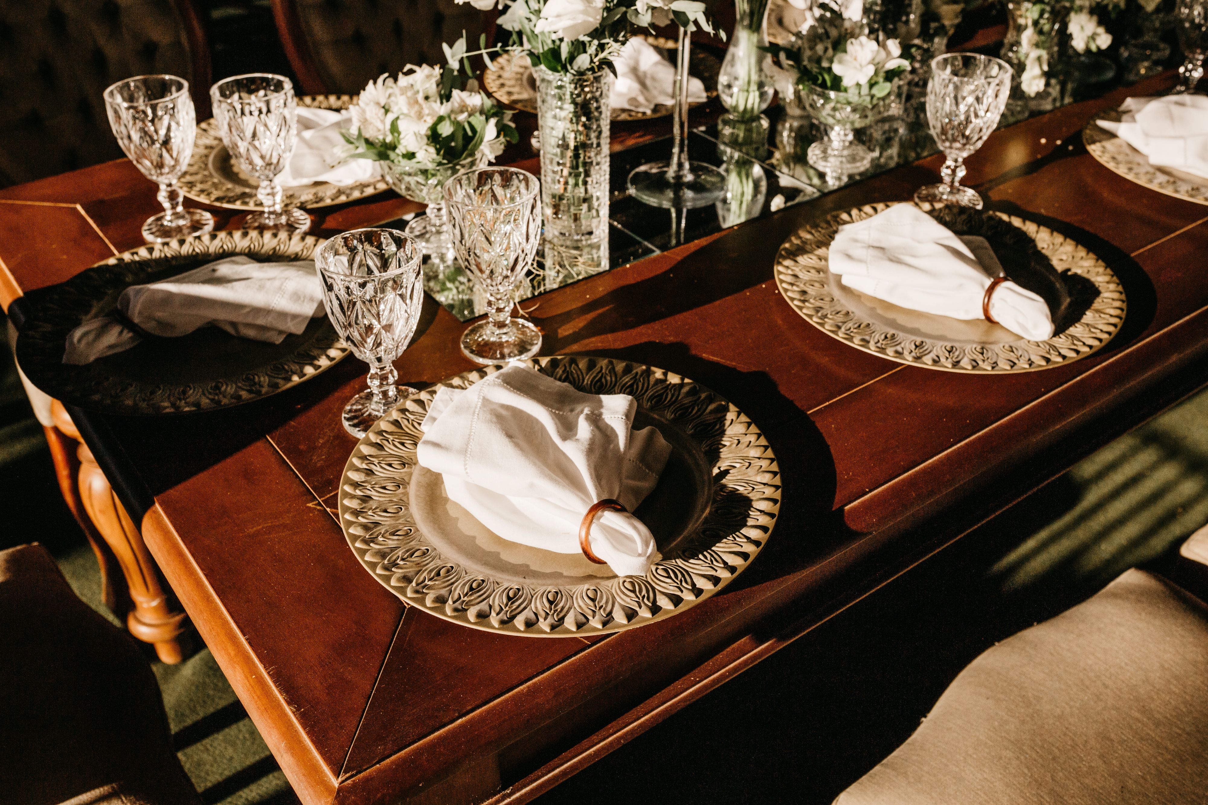 Luxurious table setup featuring ornate plates, crystal glassware, and floral decor.