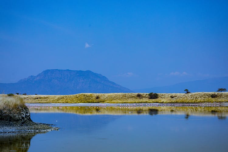 Lake Near Mountain Under Blue Sky