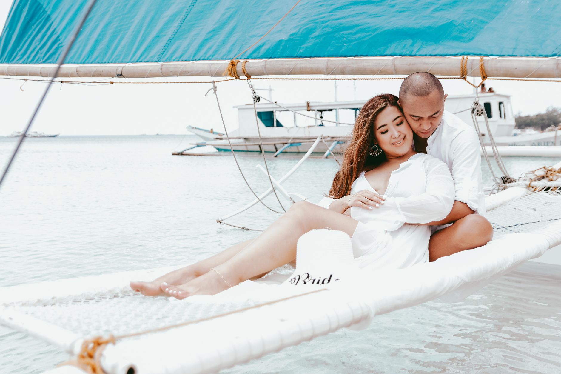 A couple enjoying a romantic moment on a sailboat at the seaside, Philippines.