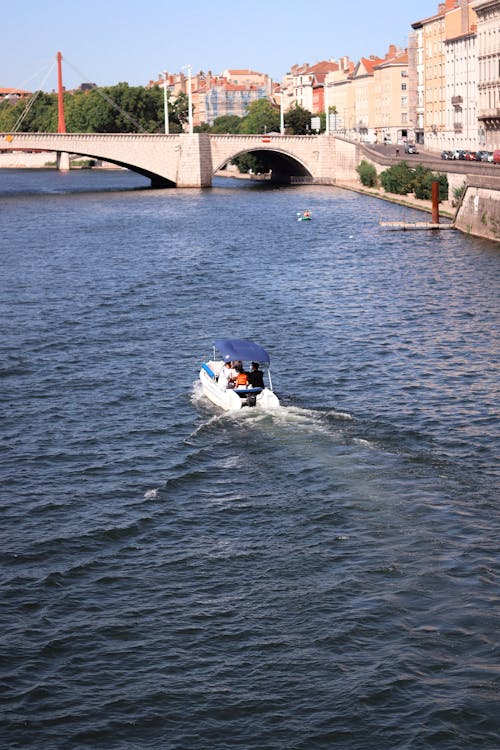People Riding a Boat Through the Bridge