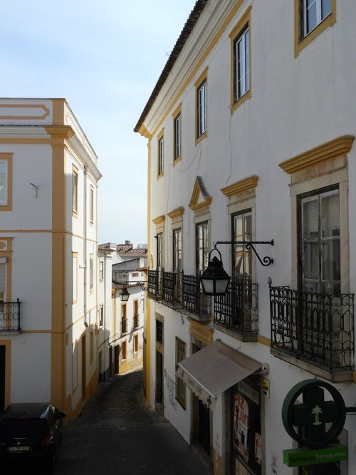 Free A picturesque narrow street lined with traditional buildings in Évora, Portugal, captured in daylight. Stock Photo