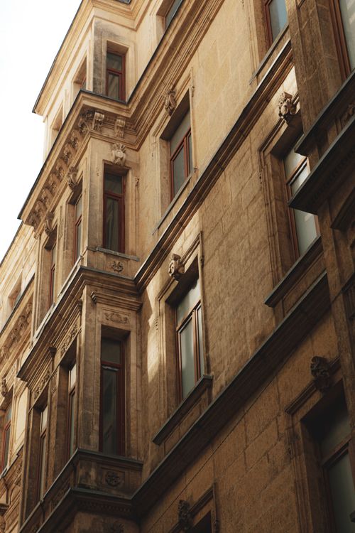 Free Low angle view of a historic stone building facade with detailed architecture under natural light. Stock Photo