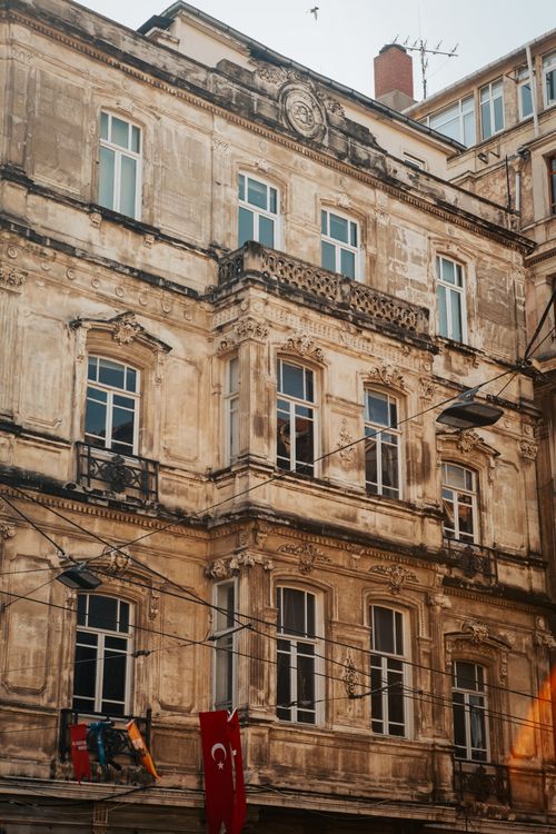 Free Low angle view of an old European-style building with Turkish flags hanging outside, captured on a sunny day. Stock Photo