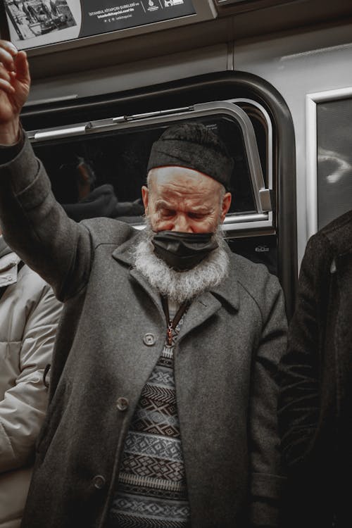 Man in Gray Coat Wearing Black Face Mask