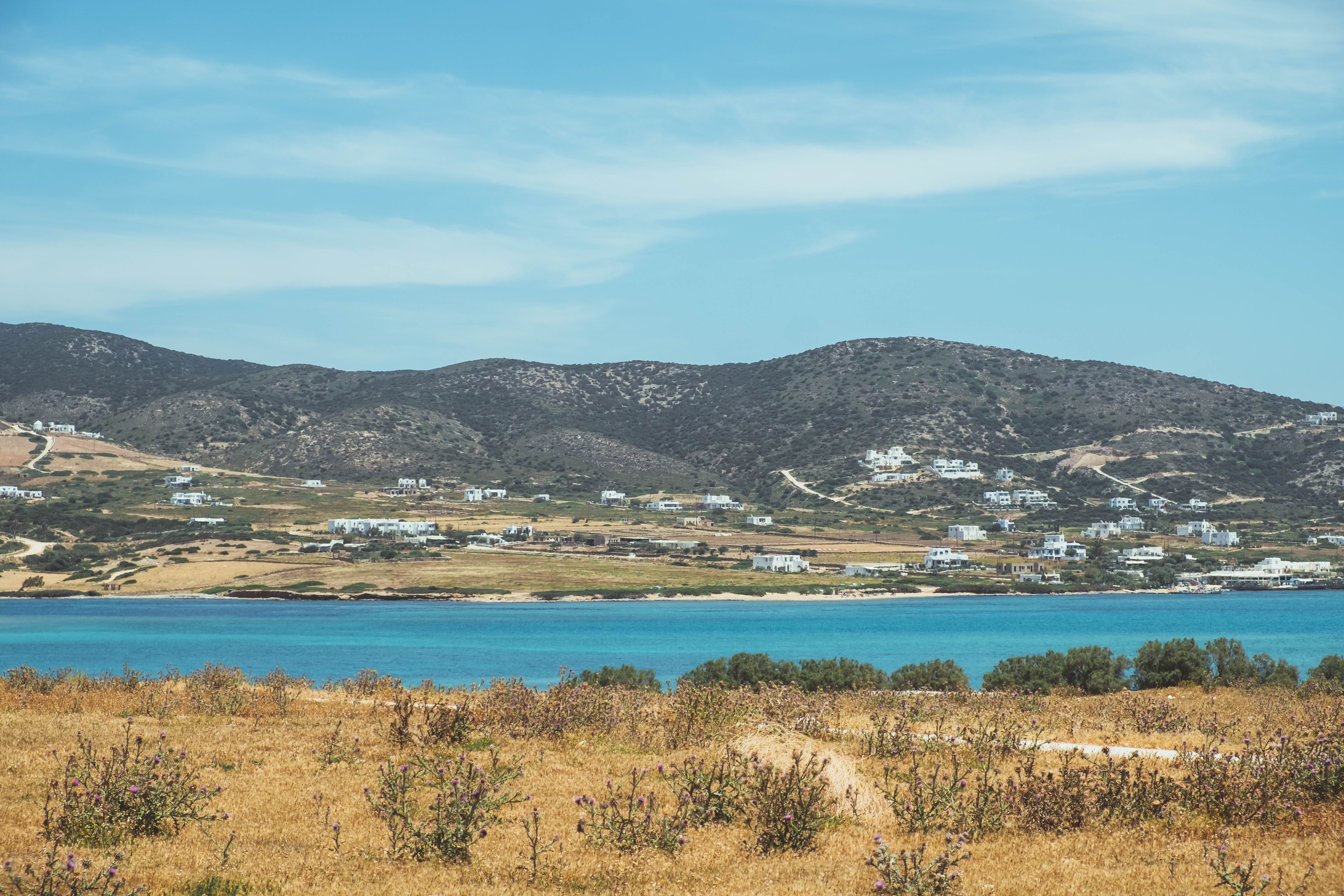 Picturesque coastal scene with clear skies, azure waters, and distant mountains.