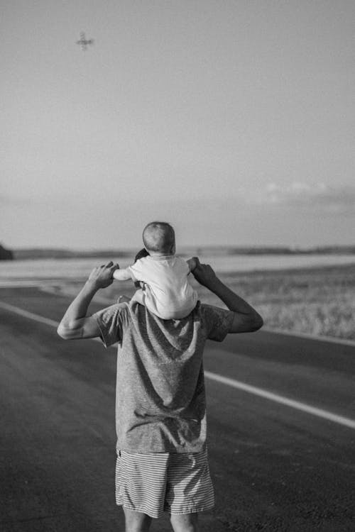 A Man Carrying a Baby on his Shoulder 