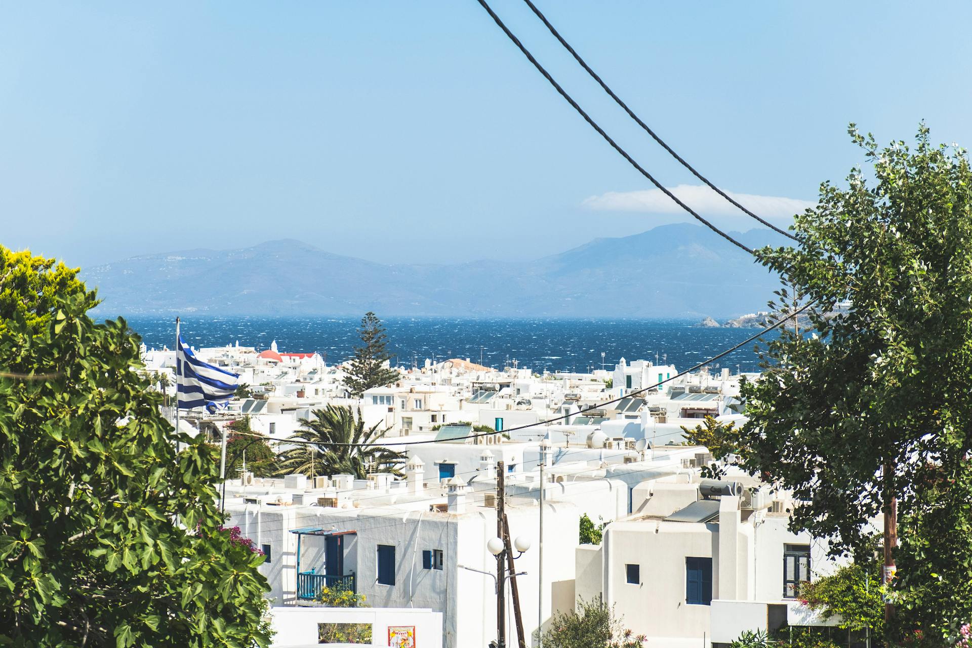 View of Mykonos town with traditional Cycladic architecture and Aegean Sea backdrop.
