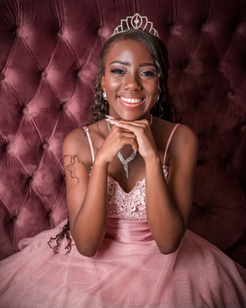 Free Smiling African American woman in pink dress and tiara, elegant portrait. Stock Photo
