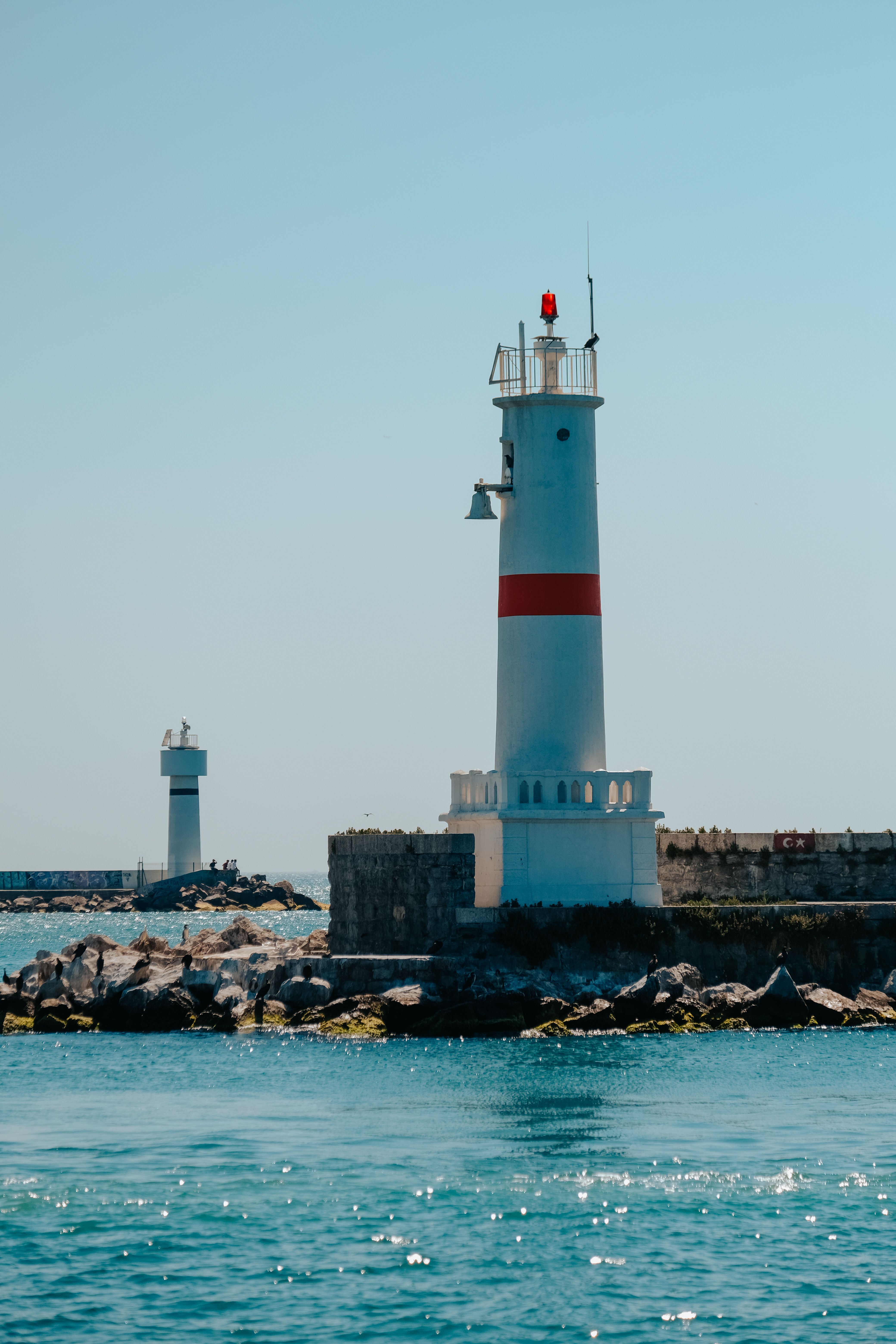 White and Red Lighthouse Near Body of Water · Free Stock Photo
