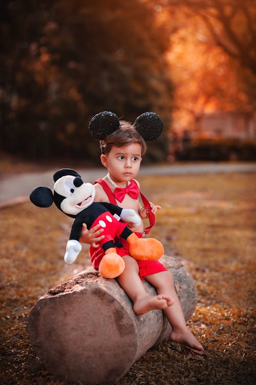 Free A Boy Holding a Mickey Mouse Stuffed Toy Stock Photo