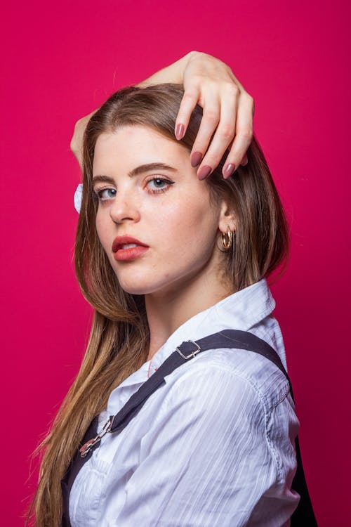 Blonde Woman With Hand on Her Hair in Pink Background 