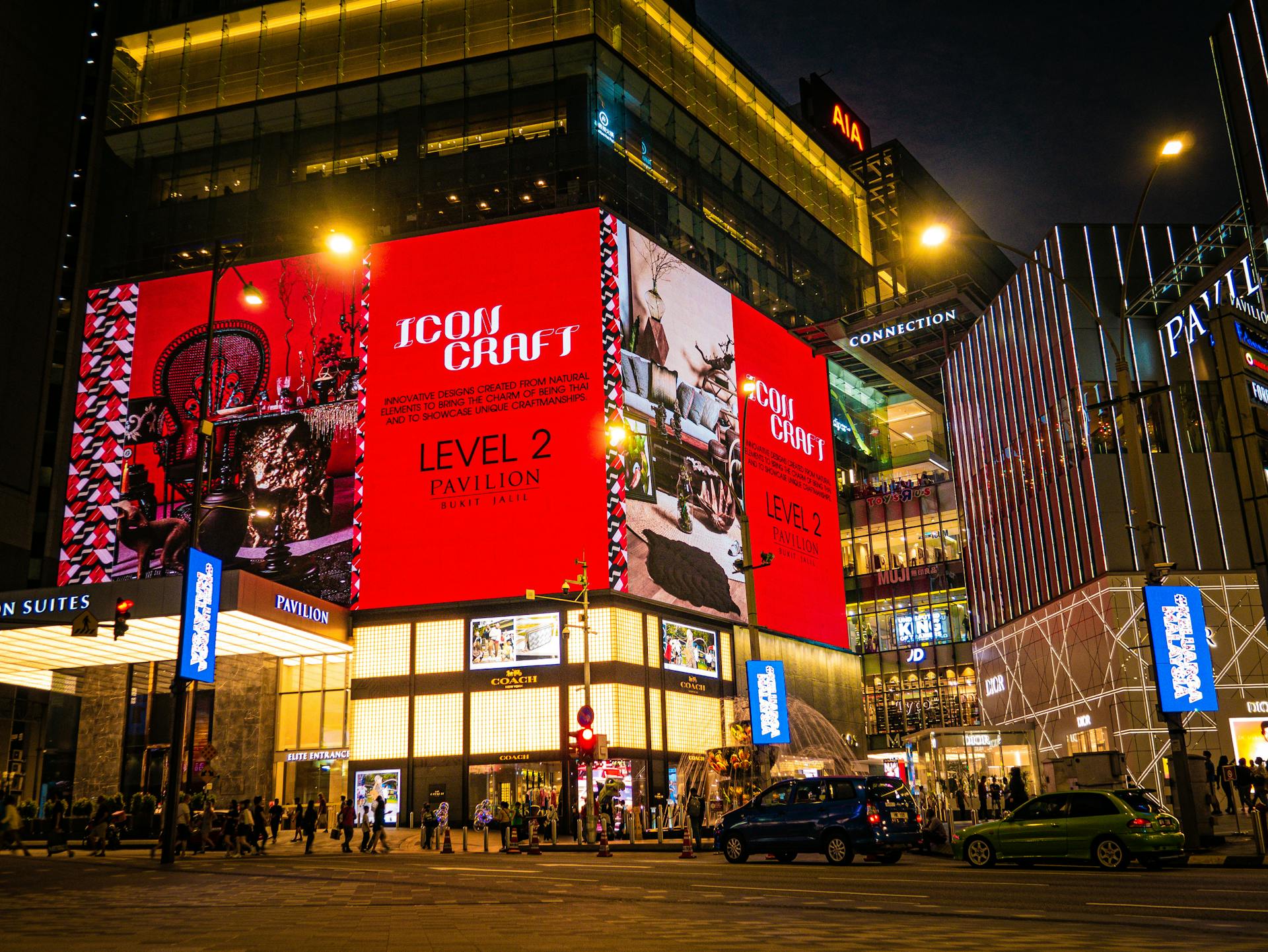 Vibrant nighttime view of Pavilion Kuala Lumpur with bright digital displays and pedestrians.