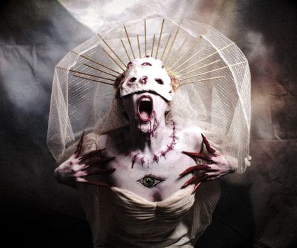 Gothic woman with a haunting costume, veil, and painted mask in an artistic horror portrait.