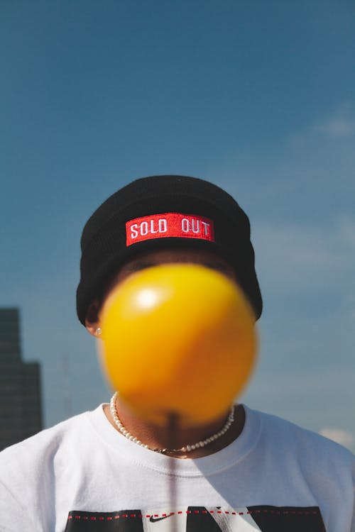 Yellow Ball Covering the Face on a Portrait of a Man 