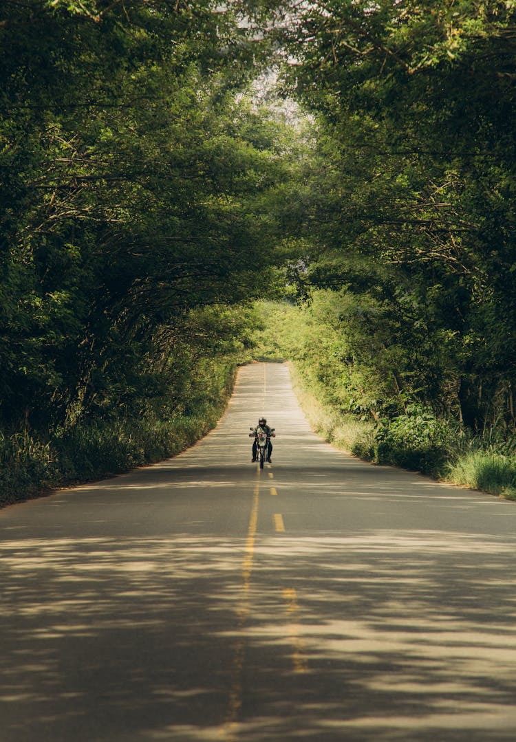 Person Riding Motorcycle Along A Road