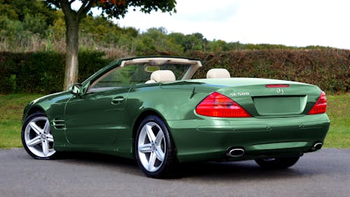 Green Convertible Car on Concrete Pavement