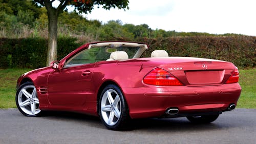 Red Mercedes-Benz SL500 Parked Near a Tree