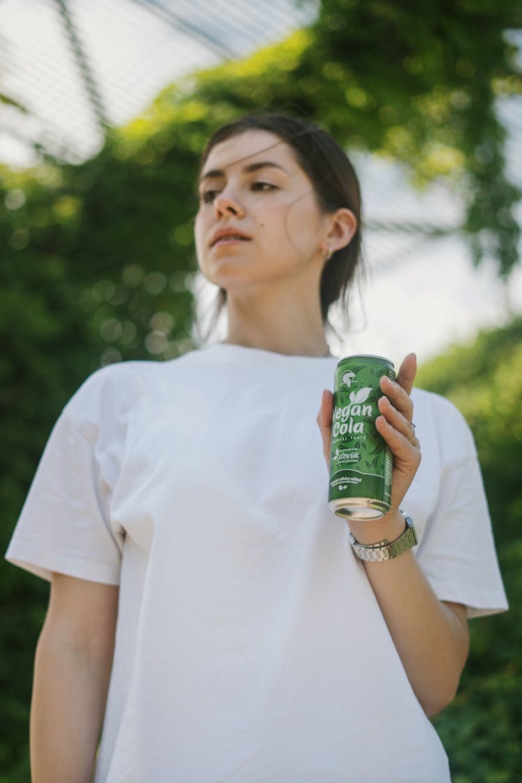 Woman In White Shirt Holding A Canned Drink