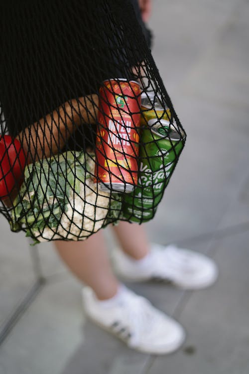 A Person Holding a Net Bag with Groceries