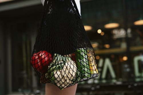 Vegetables and Cans Inside a Net Bag