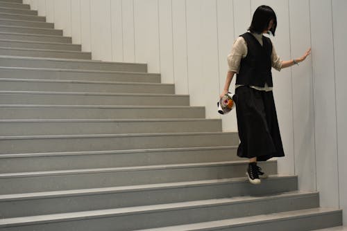 A Woman in Black Skirt Walking Down the Stairs