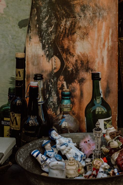 Free A nostalgic display of vintage bottles and small figurines in a bowl, offering an eclectic mix of objects. Stock Photo