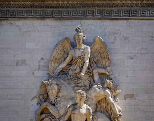 Free Close-up of a Baroque-style angel sculpture on a textured stone wall. Stock Photo