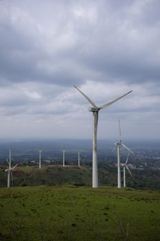 White Wind Turbine on Green Grass Field Under White Clouds