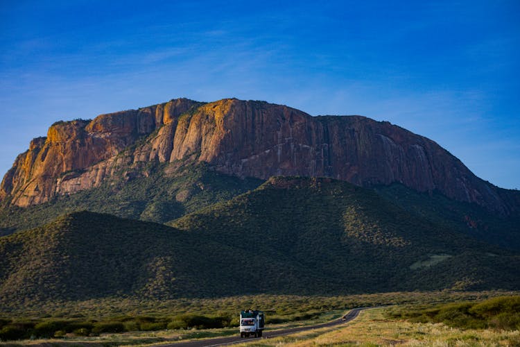 Moving Truck On Road Near Mountain 