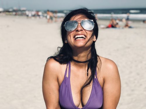Free Smiling woman in sunglasses enjoying a sunny day at Atlantic City beach. Stock Photo