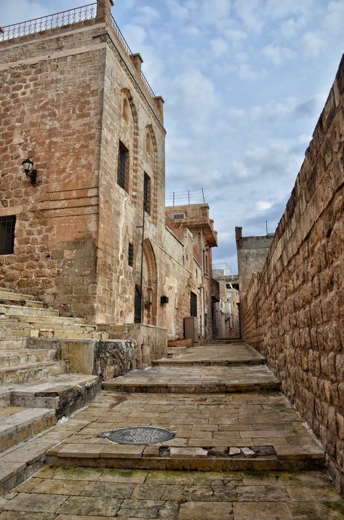 Free Explore an ancient stone alleyway with historic architecture and steps in an urban setting. Stock Photo