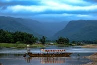 在郁郁葱葱的绿化和雄伟的山脉间，乘船沿河探索宁静之旅，是亲近大自然的完美选择