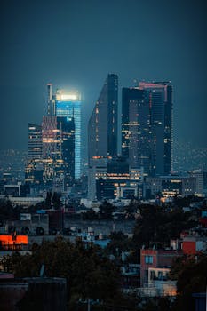 Explore the illuminated skyline of Mexico City at night, showcasing modern architecture and urban vibrancy.