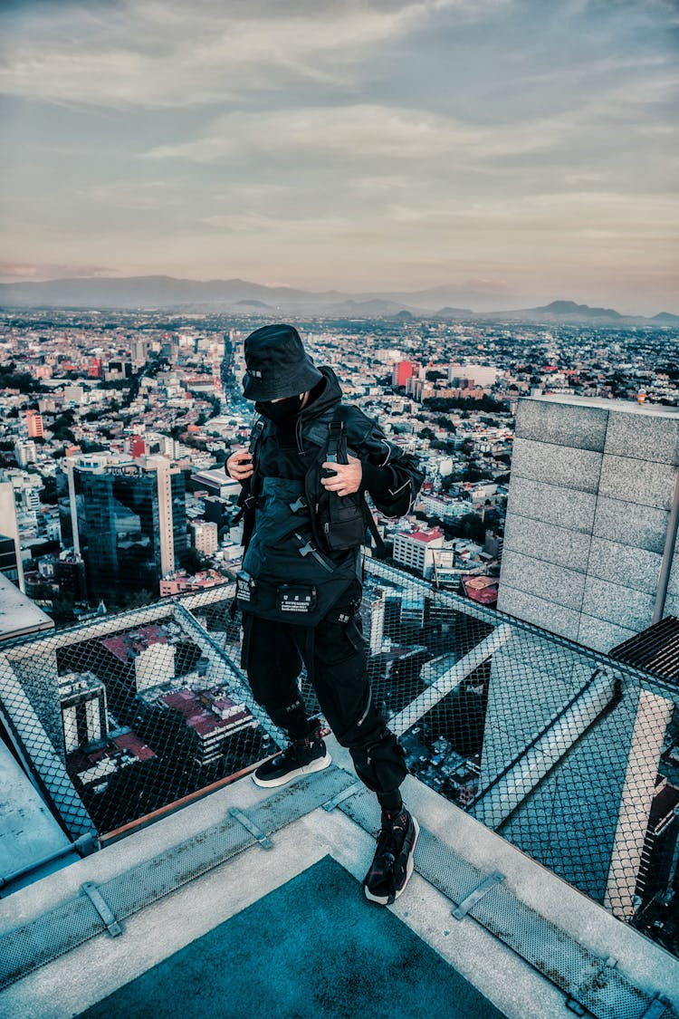 Man Standing On The Edge Of A Rooftop 