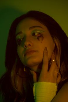 A dramatic portrait of a woman with glitter makeup, expressing deep emotions.