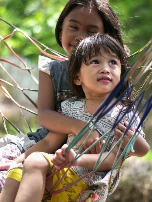 Free Two young girls embrace joyfully on a hammock outdoors, exuding warmth and love. Stock Photo