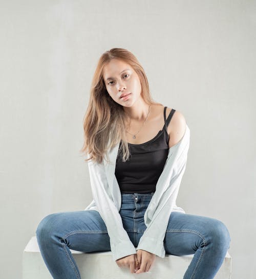 A Woman Wearing Cardigan and Denim Jeans