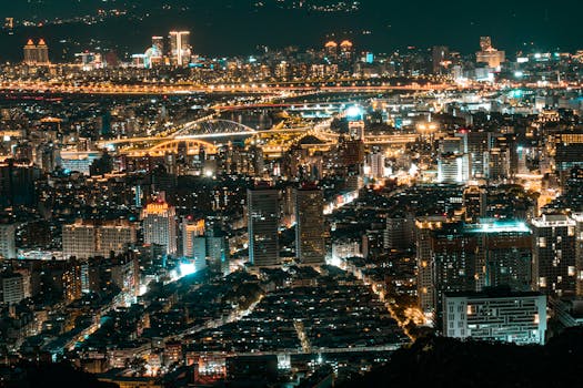 A stunning aerial cityscape of Taipei illuminated at night, showcasing modern skyscrapers and vibrant lights.