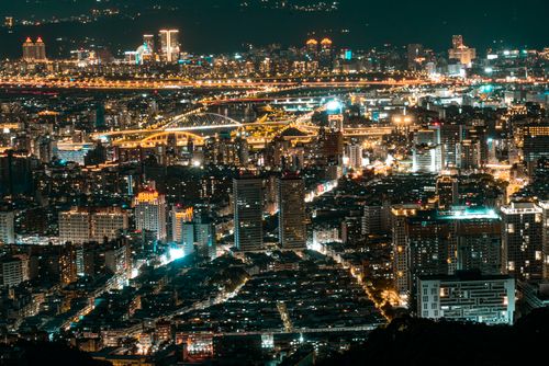 Free A stunning aerial cityscape of Taipei illuminated at night, showcasing modern skyscrapers and vibrant lights. Stock Photo