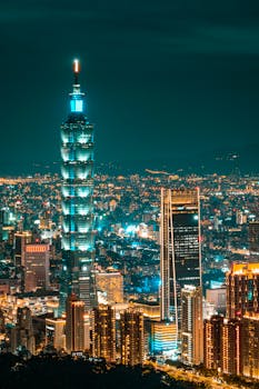 Stunning aerial view of Taipei 101 illuminated at night, showcasing the urban skyline.