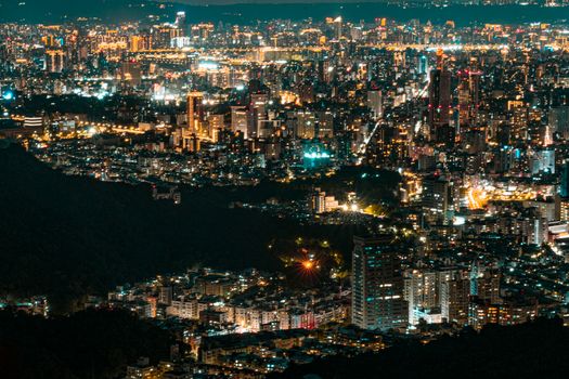 Stunning aerial view of a city skyline at night with illuminated skyscrapers.