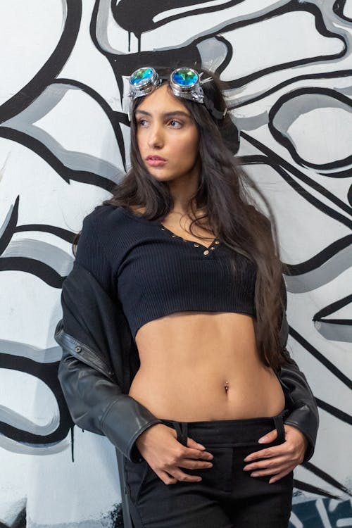 Woman in Black Crop Top Leaning on a Wall