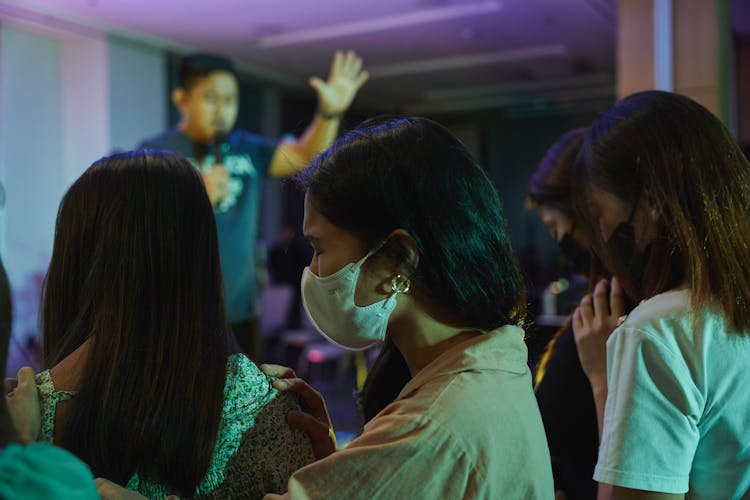 People Wearing Face Masks Praying At A Prayer Meeting 