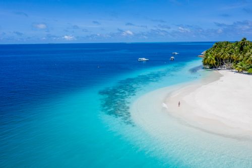 Free A breathtaking aerial view of Guraidhoo Beach in the Maldives with azure waters and palm trees. Stock Photo