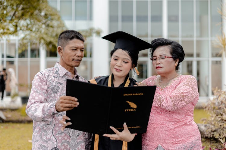 Asian Family During Graduation With Diploma