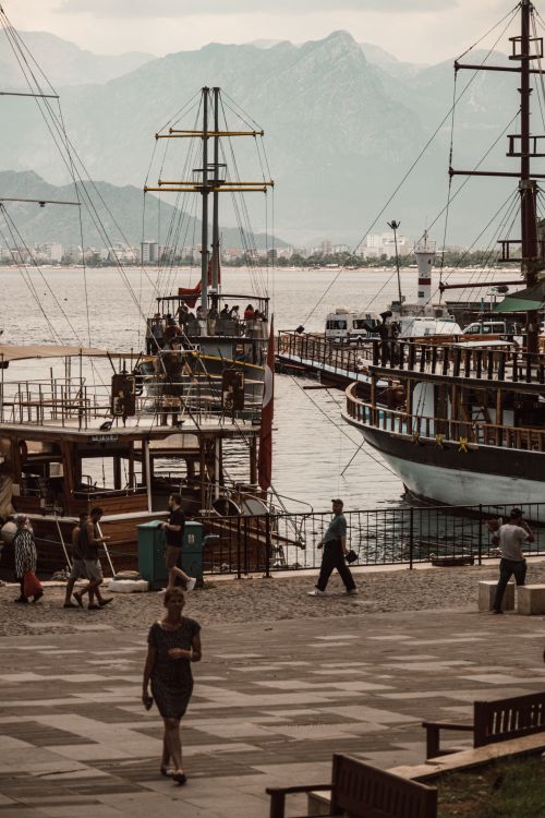 Free Scenic view of a bustling harbor with boats and distant mountains, capturing urban life by the sea. Stock Photo