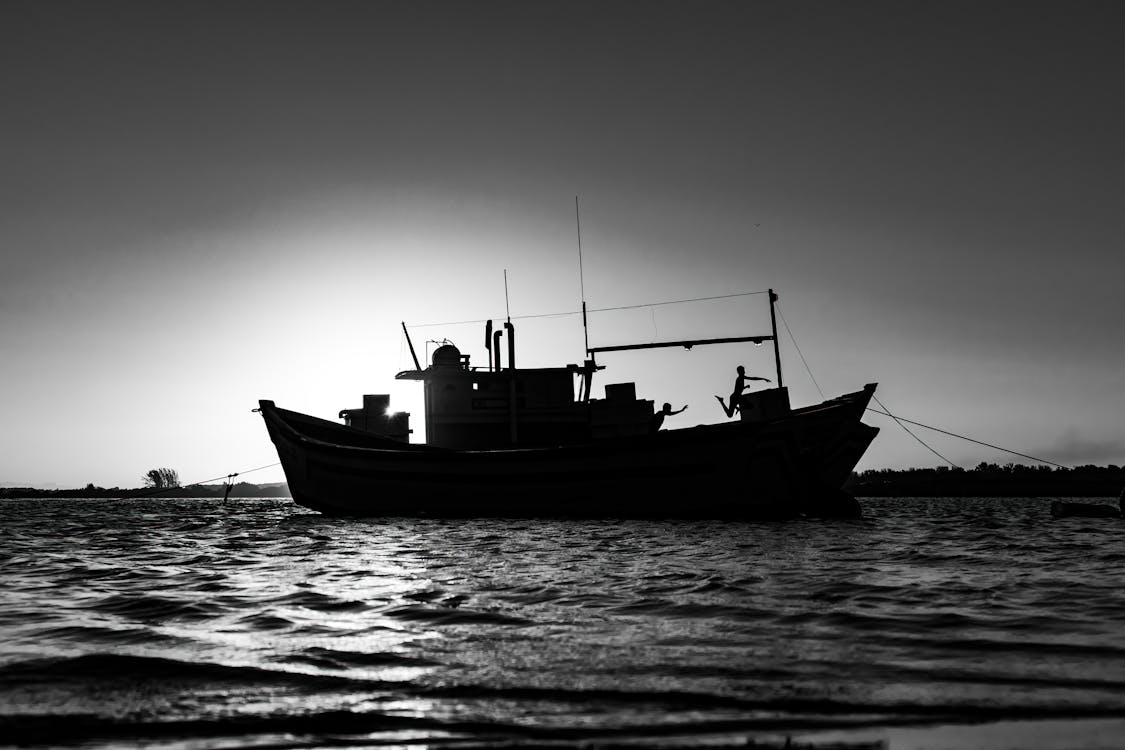 Grayscale Photo of Boat on Sea