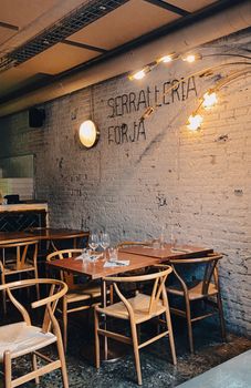 Inviting bohemian-style cafe with wooden chairs in Barcelona, Spain.