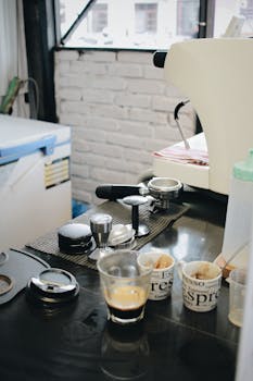 A detailed view of an espresso machine setup with cups and accessories in a modern café setting.